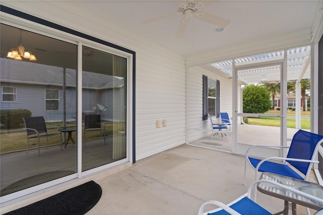 sunroom / solarium with ceiling fan with notable chandelier