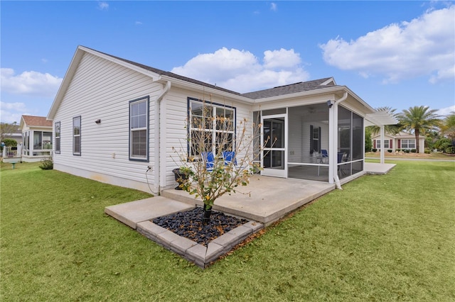 back of house featuring a lawn and a sunroom