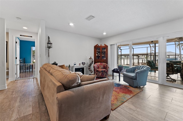 living room with light hardwood / wood-style floors and a textured ceiling