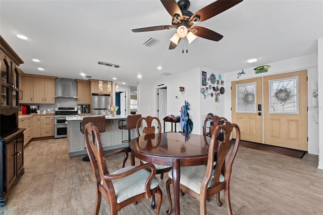 dining room featuring ceiling fan, french doors, and light wood-type flooring