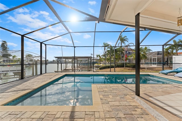 view of pool with glass enclosure, a water view, and a patio