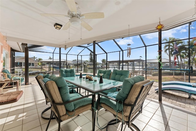 view of patio / terrace featuring a water view, glass enclosure, and ceiling fan