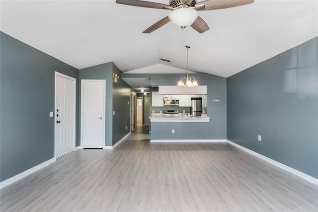 unfurnished living room with hardwood / wood-style floors, ceiling fan with notable chandelier, vaulted ceiling, and sink