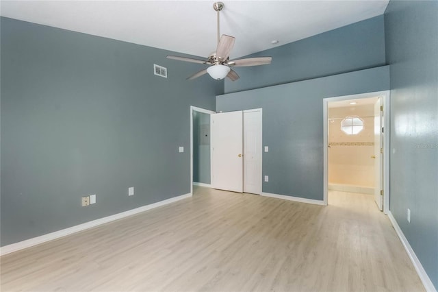 unfurnished bedroom with ceiling fan, high vaulted ceiling, ensuite bathroom, and light hardwood / wood-style floors