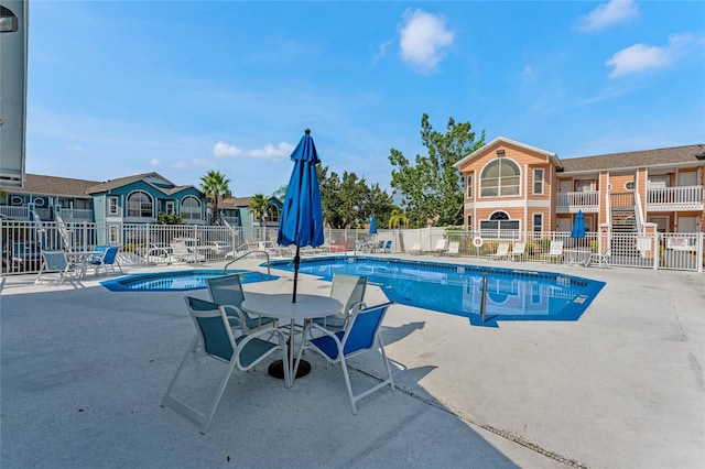 view of swimming pool featuring a community hot tub and a patio