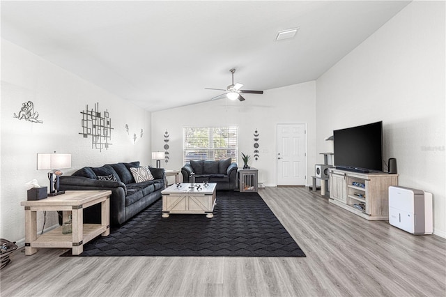 living room featuring ceiling fan, light hardwood / wood-style flooring, and vaulted ceiling