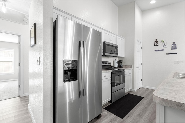 kitchen featuring white cabinetry, stainless steel appliances, and light hardwood / wood-style floors