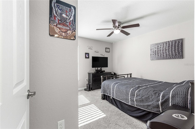 carpeted bedroom with ceiling fan and a textured ceiling