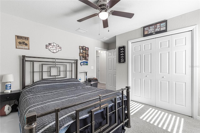 carpeted bedroom featuring ceiling fan and a closet