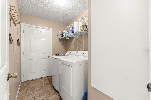 clothes washing area with independent washer and dryer and a textured ceiling