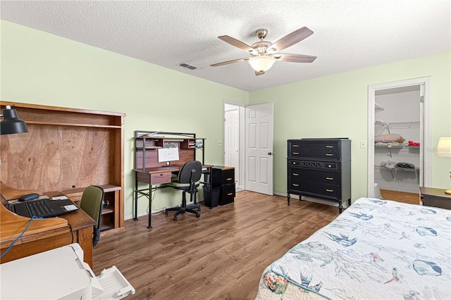 bedroom featuring a closet, ceiling fan, hardwood / wood-style floors, and a textured ceiling