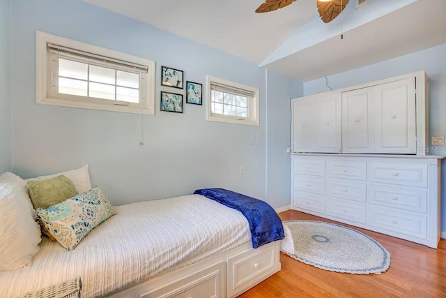 bedroom with ceiling fan, lofted ceiling, and light hardwood / wood-style flooring