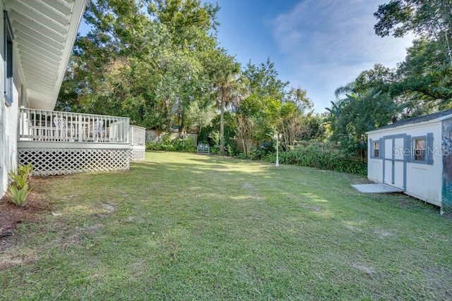 view of yard featuring a storage unit and a deck