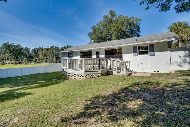 rear view of house featuring a lawn and a wooden deck