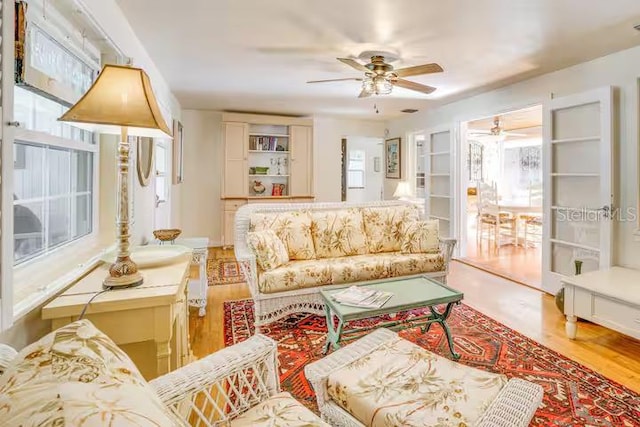 living room with hardwood / wood-style flooring and ceiling fan