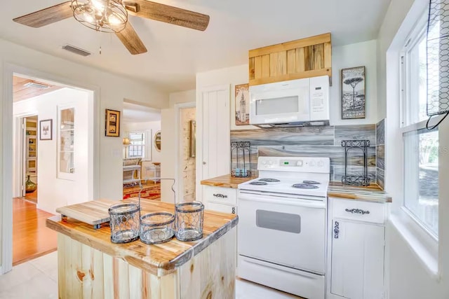 kitchen featuring butcher block countertops, white appliances, a wealth of natural light, and tasteful backsplash