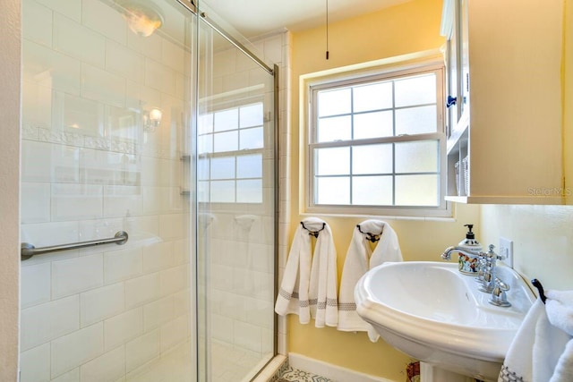 bathroom with baseboards, a sink, and a stall shower