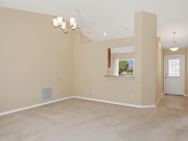 empty room with carpet floors, ceiling fan with notable chandelier, and high vaulted ceiling