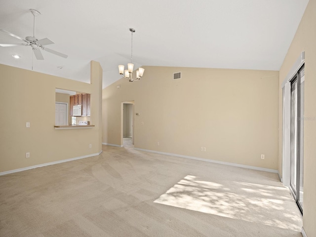 empty room with light carpet, high vaulted ceiling, and ceiling fan with notable chandelier