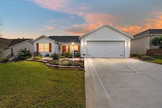 single story home featuring a lawn and a garage