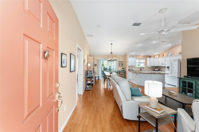 living room featuring light hardwood / wood-style flooring, ceiling fan, lofted ceiling, and sink