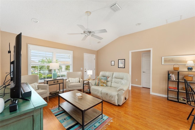 living room featuring ceiling fan, lofted ceiling, and light wood-type flooring