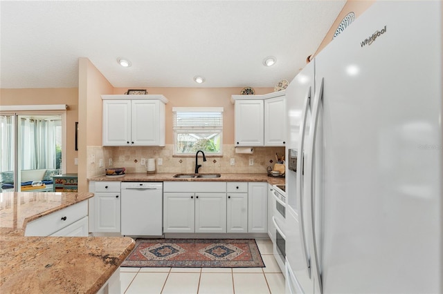 kitchen featuring white appliances, white cabinets, sink, light stone countertops, and light tile patterned flooring