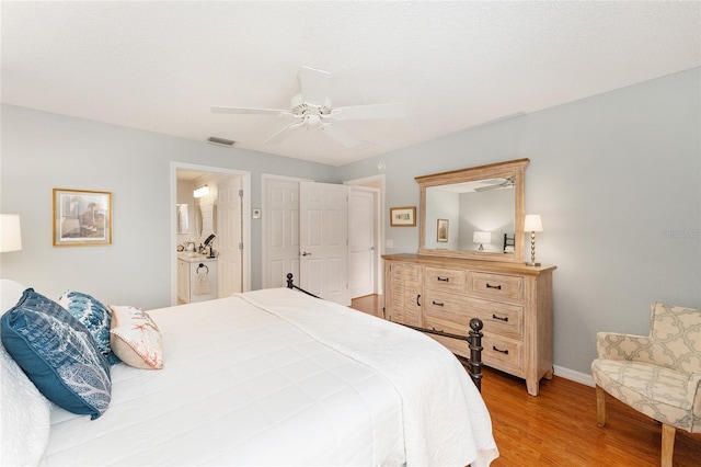 bedroom with light wood-type flooring, ensuite bath, and ceiling fan