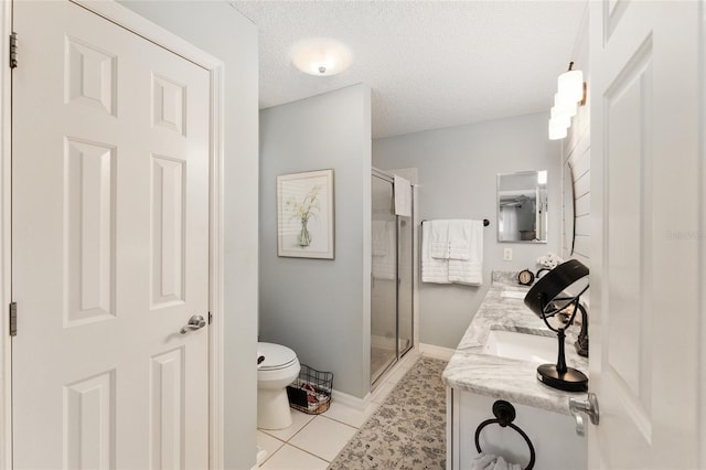 bathroom with tile patterned flooring, vanity, a shower with door, and a textured ceiling