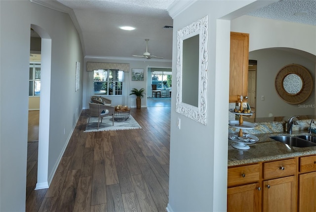 hallway featuring sink, a textured ceiling, crown molding, and dark hardwood / wood-style floors