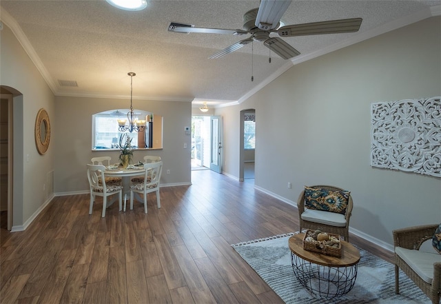 dining area featuring dark wood-type flooring, a textured ceiling, and ornamental molding