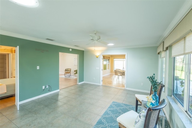 interior space featuring a healthy amount of sunlight, ceiling fan, and crown molding