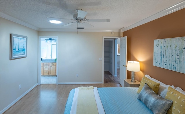 bedroom with ensuite bath, ceiling fan, light wood-type flooring, and crown molding