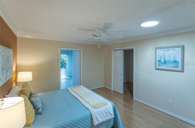 bedroom featuring ceiling fan, light hardwood / wood-style floors, crown molding, and a textured ceiling