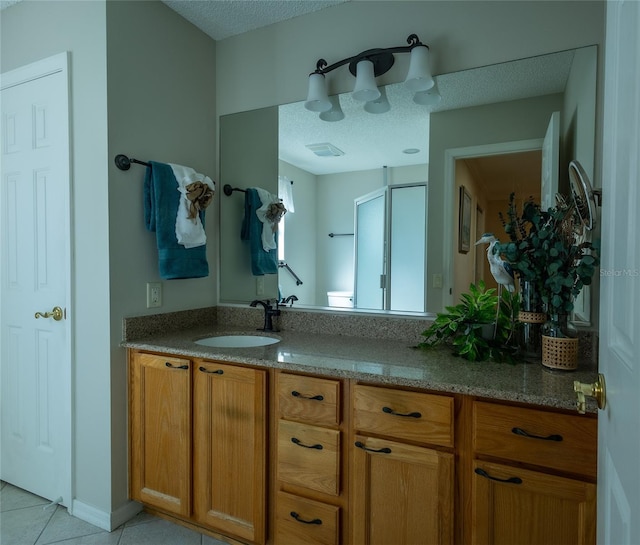 bathroom featuring a textured ceiling, tile patterned flooring, and vanity