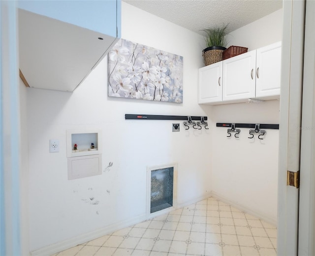 washroom featuring electric dryer hookup, washer hookup, a textured ceiling, and cabinets