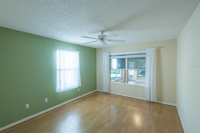 spare room featuring a textured ceiling, ceiling fan, and light hardwood / wood-style floors