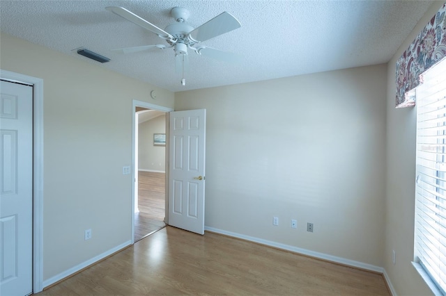 unfurnished bedroom featuring a textured ceiling, ceiling fan, and light hardwood / wood-style flooring