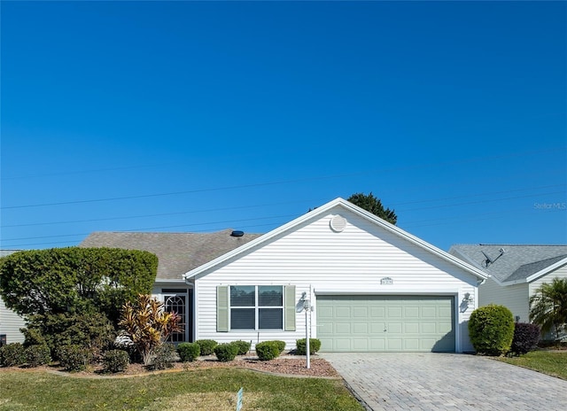 ranch-style home featuring a garage and a front lawn