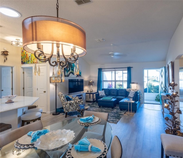 dining area featuring lofted ceiling, a notable chandelier, and wood-type flooring