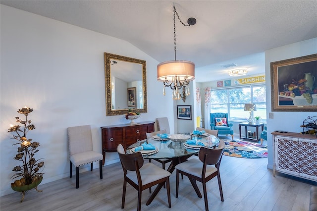 dining room featuring hardwood / wood-style flooring and vaulted ceiling