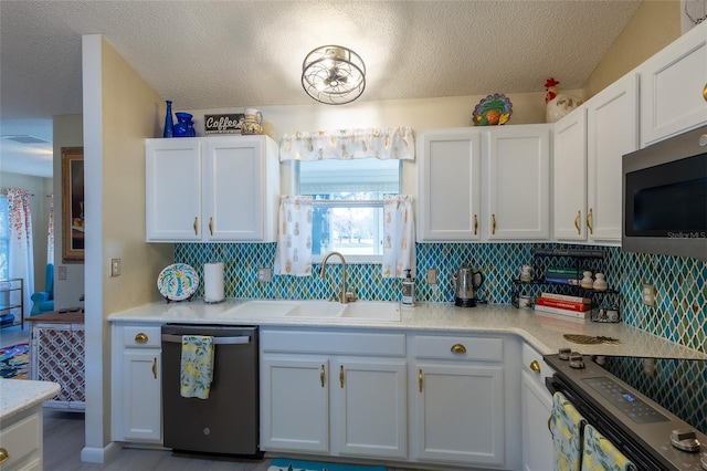 kitchen with sink, white cabinets, tasteful backsplash, and appliances with stainless steel finishes