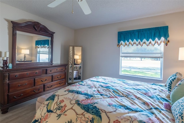 bedroom featuring ceiling fan, a textured ceiling, and wood-type flooring