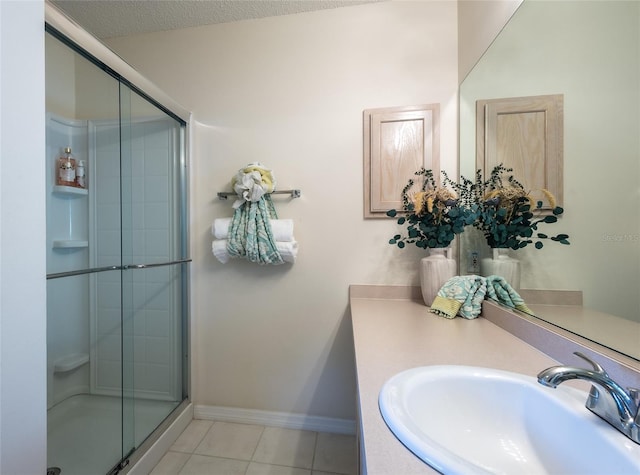 bathroom featuring a textured ceiling, tile patterned floors, walk in shower, and vanity