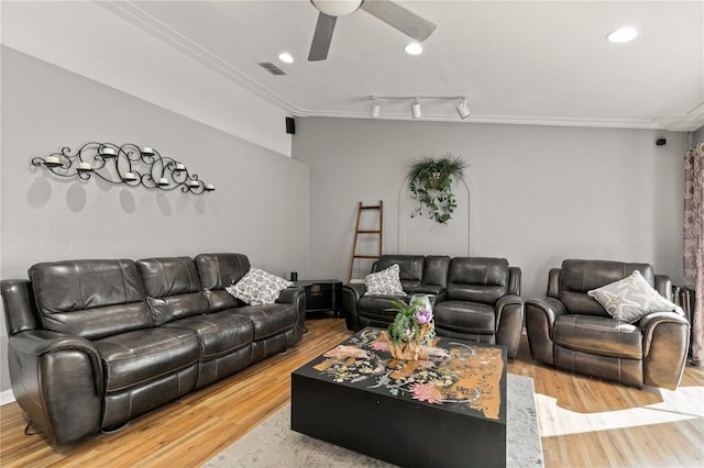 living room with crown molding, ceiling fan, rail lighting, and hardwood / wood-style floors