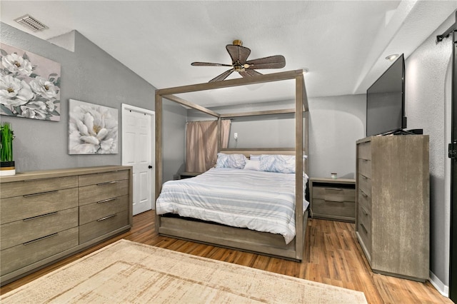 bedroom featuring ceiling fan, vaulted ceiling, and light hardwood / wood-style flooring