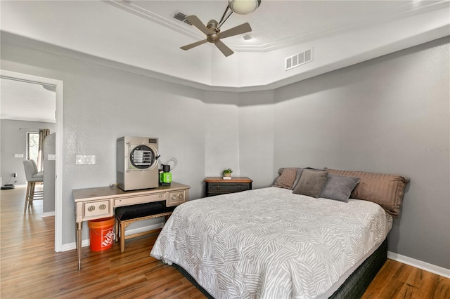 bedroom featuring ceiling fan, ornamental molding, and dark hardwood / wood-style flooring