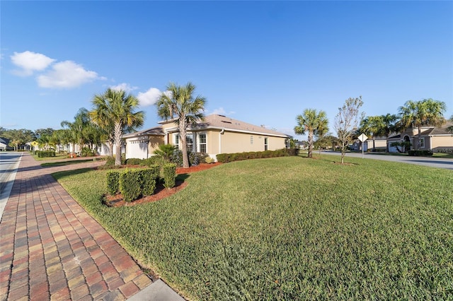 view of front of house with a garage and a front lawn