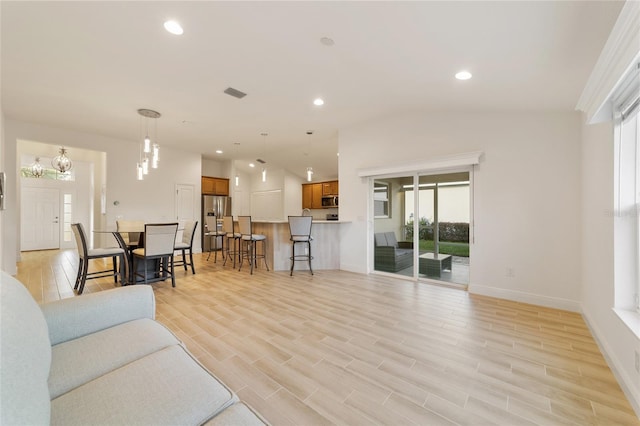 living room featuring light hardwood / wood-style floors and vaulted ceiling