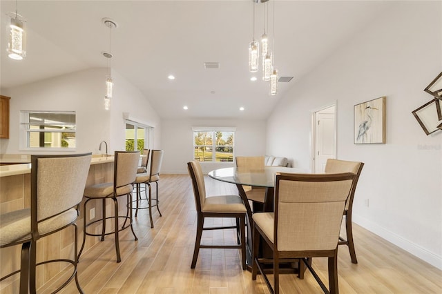 dining room featuring vaulted ceiling and light wood-type flooring